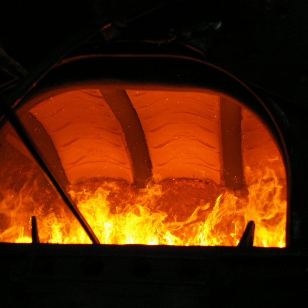 Blick durch die offene Feuertür in einen brennenden Kessel (Beispielbild)
